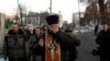Priest is overcome with emotion as he holds memorial service for protesters killed during clashes with police, near Independence Square, Kiev, Feb. 21, 2014.