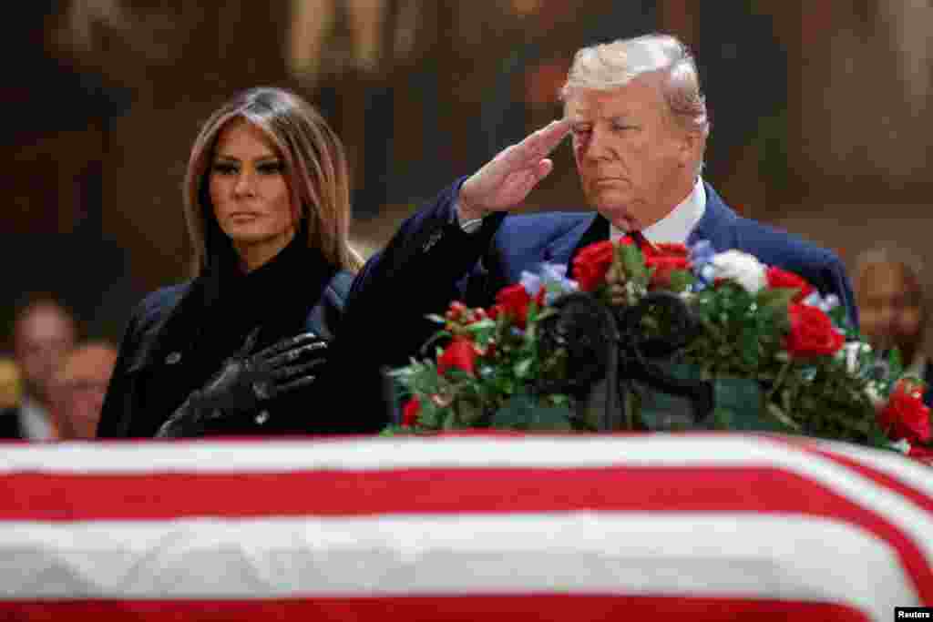 Presiden AS Donald J. Trump, dengan Ibu Negara Melania Trump, memberikan penghormatan kepada peti jenazah mantan Presiden AS George H.W. Bush di Rotunda Gedung Capitol, di&nbsp; Washington, DC, 3 Desember 2018.