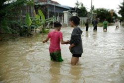 Girls wander through a flooded road in Spean Tmor commune, Dangkoa district, Phnom Penh City, Cambodia, on Oct. 14, 2020. (Malis Tum/VOA Khmer)