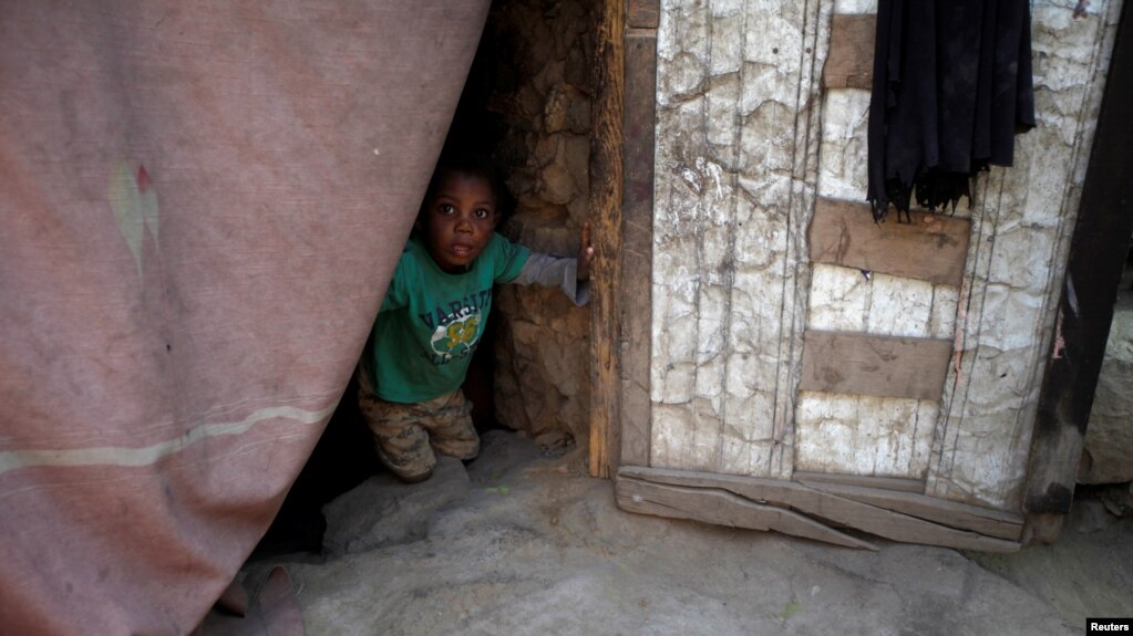 Seorang bocah yang mengungsi dari kota pelabuhan Laut Merah Hodeida terlihat dari balik tirai pintu di tempat penampungan di Sanaa, Yaman, 2 November 2018. (Foto: dok).