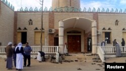 People stand outside Al Rawdah mosque, where a bomb exploded, in Bir Al-Abed, Egypt, Nov. 25, 2017. 