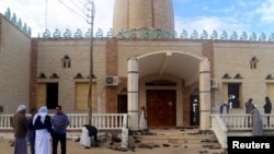 People stand outside Al Rawdah mosque, where a bomb exploded, in Bir Al-Abed, Egypt, Nov. 25, 2017. 