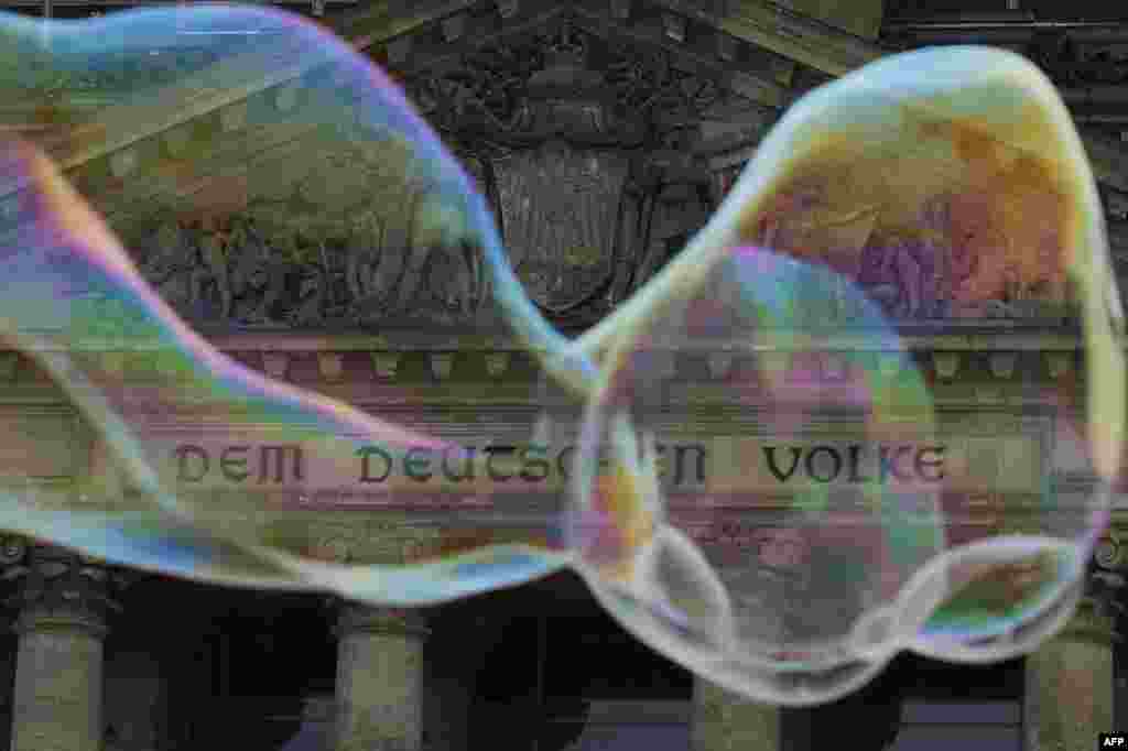 Soap bubbles float past the lettering &quot;Dem Deutschen Volke&quot; (To the German People) written on the Reichstag building housing the Bundestag (lower house of parliament) in Berlin, Sept. 22, 2013.