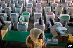 A Kenyan election volunteer walks past ballot boxes and electoral material to be distributed to various polling stations in Nairobi, Kenya, Aug. 7, 2017. Kenyans are due to go to the polls on Aug. 8. to vote in a general election.