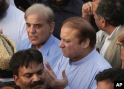 FILE - Pakistani jailed former minister of Pakistan Nawaz Sharif (C) prays during a funeral of his wife Kulsoom Nawaz with his brother Shahbaz Sharif in Lahore, Pakistan, Sept. 14, 2018.