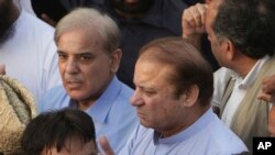 FILE - Pakistani jailed former minister of Pakistan Nawaz Sharif (C) prays during a funeral of his wife Kulsoom Nawaz with his brother Shahbaz Sharif in Lahore, Pakistan, Sept. 14, 2018.