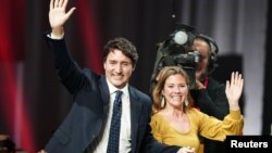 Nhà lãnh đạo của Đảng Tự do và Thủ tướng Canada Justin Trudeau cùng vợ Sophie Gregoire Trudeau vẫy tay chào những người ủng hộ tại trung tâm hội nghị Palais des Congres ở Montreal, Quebec, hôm hôm 22/10.