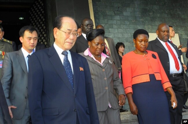 FILE - North Korea’s ceremonial leader, Kim Yong Nam, foreground,left, the head of North Korea’s parliament, is escorted into Uganda's parliament by its Speaker Rebecca Kadaga, center, Commissioner Rosemary Seninde, center-right, and Uganda's Foreign Affairs Minister Asuman Kiyingi, right, in Kampala, Uganda, Oct. 30,2014.