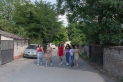 From left, Silvia Sinani, 24, Dijana Ferhatovic, 18, Zivka Ferhatovic, 20, Elma Dalipi, 14, Selma Dalipi, 14, and Zlata Ristic, 27, members of the Pretty Loud band, walk along a street in their neighborhood in Belgrade, Serbia. (AP Photo)