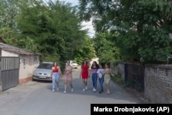 From left, Silvia Sinani, 24, Dijana Ferhatovic, 18, Zivka Ferhatovic, 20, Elma Dalipi, 14, Selma Dalipi, 14, and Zlata Ristic, 27, members of the Pretty Loud band, walk along a street in their neighborhood in Belgrade, Serbia. (AP Photo)