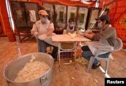 Relawan menyiapkan makanan untuk dibagikan kepada orang yang membutuhkan selama bulan suci Ramadhan, di Maan, Yordania 1 Mei 2021. (Foto: Reuters)