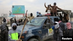 Militan Sunni merebut kendaraan polisi Irak dalam bentrokan di Ramadi, Senin (30/12). 