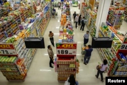 FILE - People shop in a supermarket inside a department store in Bangkok.