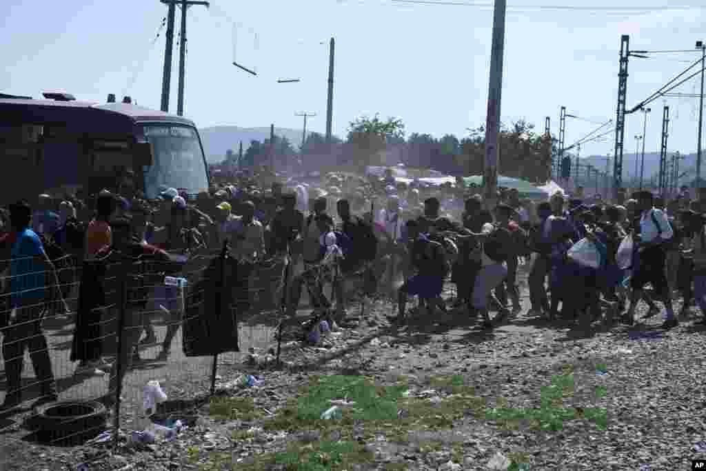 Refugees and migrants break a fence as they run to cross the border from the northern Greek village of Idomeni to southern Macedonia. More than 2,000 refugees and economic migrants wait at the small village of about 100 inhabitants every day to be let into Macedonia, from where they continue through Serbia and Hungary to seek asylum in wealthier European countries..