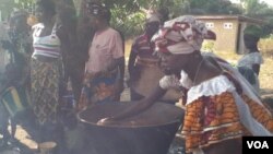 Women prepare rice to sell at an Agricultural Business Center in the community called Mile 91, Sierra Leone, Feb. 19, 2013. (N. deVries/VOA)