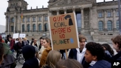 Students protest under the banner of 'Fridays for Future' in front of the German Federal Parliament, in Berlin, Germany, Friday, Dec. 14, 2018. (AP Photo/Michael Sohn)