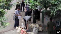 Seorang polisi memeriksa dengan seksama paket mencurigakan yang ditemukan oleh petugas penjinak bom di pusat kota Rangoon, Burma, 15 Oktober 2013 (Foto: dok).