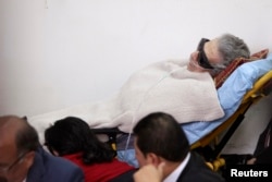 Former Guatemalan dictator Efrain Rios Montt lies on a stretcher and is covered with a blanket during his hearing at the Supreme Court of Justice in Guatemala City, Jan. 5, 2015.