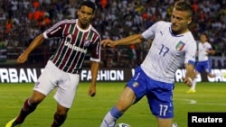 Italy's Ciro Immobile (R) fights for the ball with Fluminense's Jean during a friendly soccer match ahead of the 2014 World Cup at the Cidadania stadium in Volta Redonda, Rio de Janeiro state, Brazil, June 8, 2014.