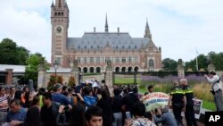 Người biểu tình, cảnh sát, và phóng viên tập trung bên ngoài Cung điện Hòa bình ở La Haye, Hà Lan, 12/7/2016, trước phán quyết của Tòa Trọng tài LHQ về tranh chấp Biển Đông.