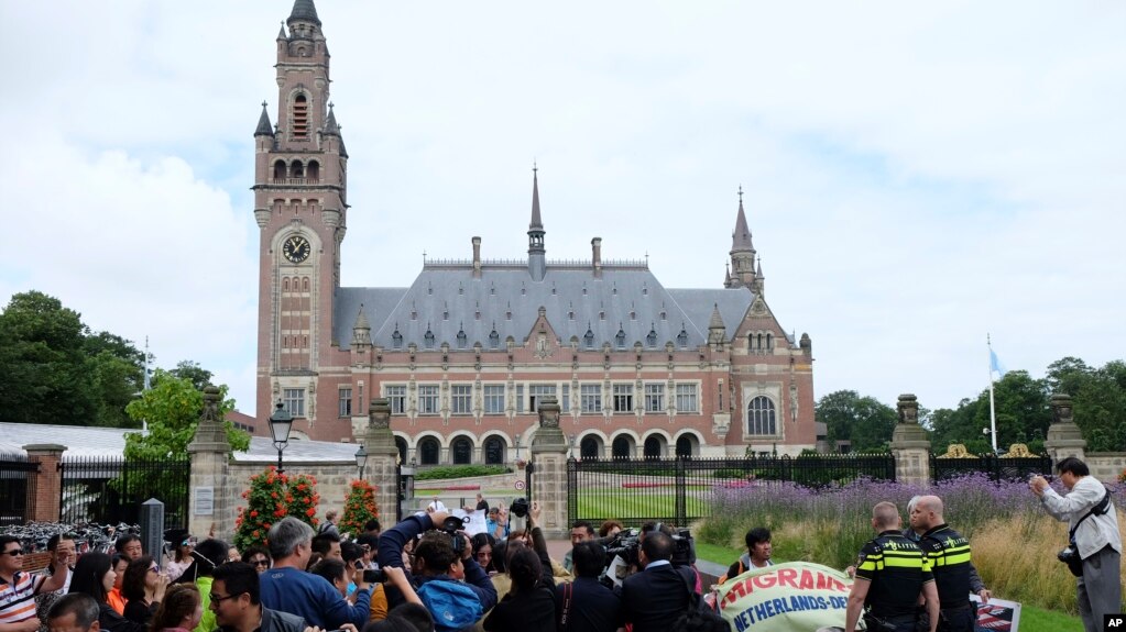Người biểu tình, cảnh sát và truyền thông tập trung bên ngoài Tòa Trọng tài Thường trực ở La Haye, Hà Lan, vào ngày 12/7/2016, trước khi tòa đưa ra phán quyết vụ kiện của Philippines chống lại yêu sách chủ quyền của Trung Quốc trên Biển Đông.