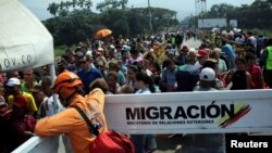 People cross the Colombian-Venezuelan border over the Simon Bolivar international bridge in Villa del Rosario, Colombia, Feb. 5, 2019. 