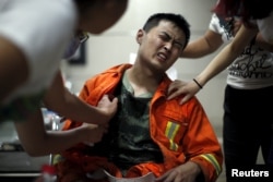 A firefighter reacts as he receives treatment at a hospital after the explosions at the Binhai new district in Tianjin, China, Aug. 13, 2015.