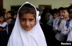 FILE - A girl attends morning assembly at the Mashal Model school in Islamabad, Pakistan, Sept. 29, 2017.