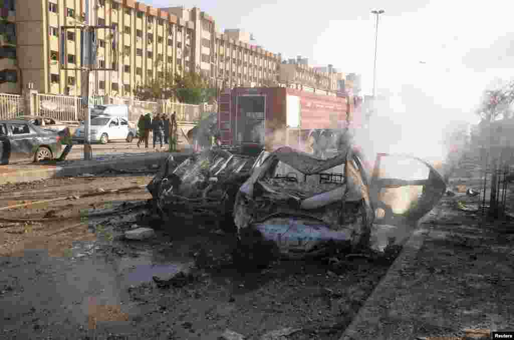 Damaged cars are seen at the site where two explosions rocked the University of Aleppo in Syria's second largest city, January 15, 2013. At least 15 people were killed and dozens wounded in two explosions that rocked the University of Aleppo in Syria's se