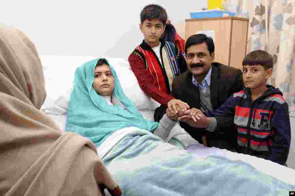 This photo issued by Queen Elizabeth Hospital shows Malala Yousafzai with her father Ziauddin, and two younger brothers Atal, right and Khushal, in Birmingham, England.