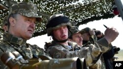 Ukrainian President Petro Poroshenko, left, watches a military exercise of the Ukrainian armed forces in Mykolaiv region, April 25, 2015.