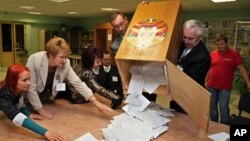 Electoral commission staff count ballot papers after voting closed at a polling station in Minsk, Belarus, Sunday, Sept. 23, 2012.