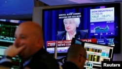 Traders work as Federal Reserve Chair Janet Yellen speaks on a television above the floor of the New York Stock Exchange (NYSE) shortly after the opening bell in New York City, U.S., June 15, 2016