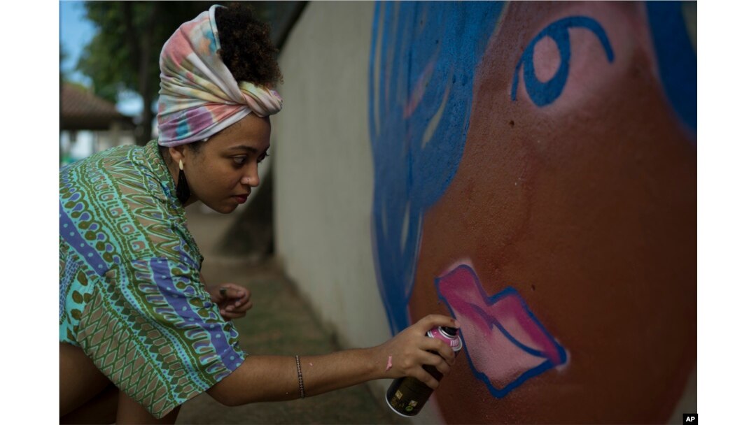 Graffiti artist Maiara Viana Rodrigues paints a mural at her home neighborhood in Rio de Janeiro, Brazil, March 7, 2017. "We use graffiti to end violence against women," says the 25-year-old designer and visual artist.