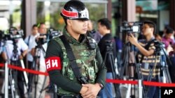 An armed Thai military police stands guard at the entrance to a hall of the Thai Army Club prior to a meeting between Thai Armed Forces Chiefs and high ranking officials in Bangkok, Thailand, May 20, 2014.