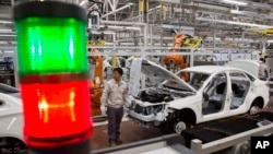 FILE - A worker assembles a car at a factory for Chinese automaker BAIC Motor in Beijing.