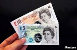 Sample polymer five and ten GB pound banknotes are displayed at the Bank of England in London, Sept. 10, 2013.