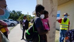 FILE - Dave, right, who declined to give his last name, from Toledo, Ohio, wears a neon vest as migrants are released from U.S. Customs and Border Protection custody, Sept. 24, 2021, in Del Rio, Texas.