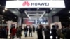 FILE - Attendees pass by a Huawei booth during the 2019 CES in Las Vegas, Nevada, U.S. Jan. 9, 2019. 