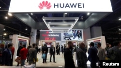 FILE - Attendees pass by a Huawei booth during the 2019 CES in Las Vegas, Nevada, Jan. 9, 2019. 