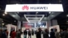 FILE - Attendees pass by a Huawei booth during the 2019 CES in Las Vegas, Nevada, Jan. 9, 2019. 