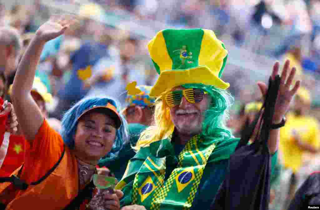 Warga China dan Brazil menunjukkan semangat mereka menjelang upacara pembukaan Olimpiade Musim Panas 2016 di Rio de Janeiro, Brazil (5/8).&nbsp;(Reuters/Kai Pfaffenbach)