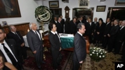 Relatives, friends and Mexican politicians surround the coffin, covered by a Mexican flag, containing the body of Mexico's former President Miguel de la Madrid during his wake in Mexico City, Sunday April 1, 2012. 