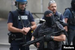 FILE - French police and anti-crime brigade members secure a street during a counterterrorism swoop at different locations in Argenteuil, a suburb north of Paris, July 21, 2016.