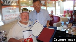 미국 캘리포니아주 랭캐스터 시 ‘크레이지 오토스’ 식당에서 이 식당 사장의 형인 허영 씨(오른쪽)가 6.25 참전 노장에게 한국 총영사관이 수여하는 ‘평화의 사도 메달’을 전달하고 있다.