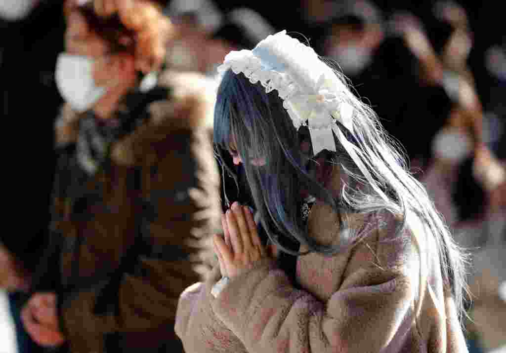 Me maska mbrojtëse mes shpërthimit të sëmundjes së koronavirusit (COVID-19), njerëzit u lutën ditën e parë të vitit të ri në tempullin Meiji në Tokio, Japoni, 1 janar 2021. REUTERS / Kim Kyung-Hoon