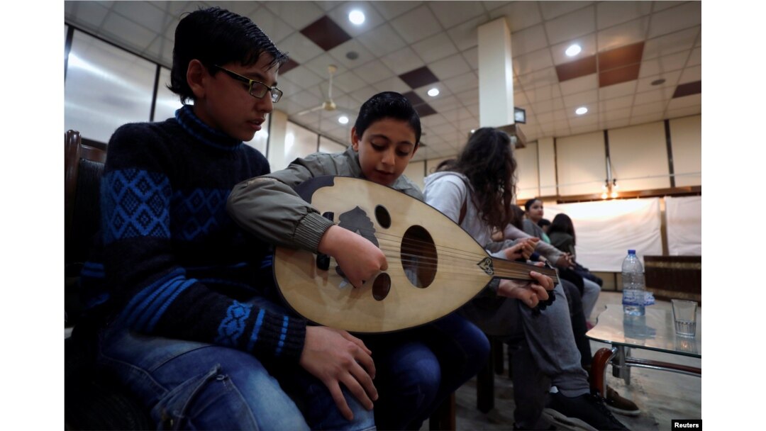 Seorang anak laki-laki memainkan alat musik oud di Institut Paduan Suara Nasional di Aleppo, Suriah, 9 Februari 2018.