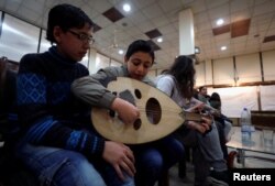 Seorang anak laki-laki memainkan alat musik oud di Institut Paduan Suara Nasional di Aleppo, Suriah, 9 Februari 2018.