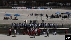 Los familiares participan en el octavo evento anual "Abrazos, no muros" en el Río Grande, en Ciudad Juárez, México, el sábado 19 de junio de 2021 y que permite encuentros entre inmigrantes a ambos lados de la frontera.