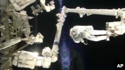 In this image made from video provided by NASA, Italian astronaut Luca Parmitano stands on the end of a robotic arm during a spacewalk outside the International Space Station, July 9, 2013. 